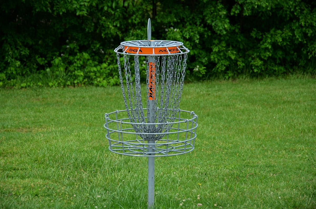 a frisbee golf cage in the middle of a field