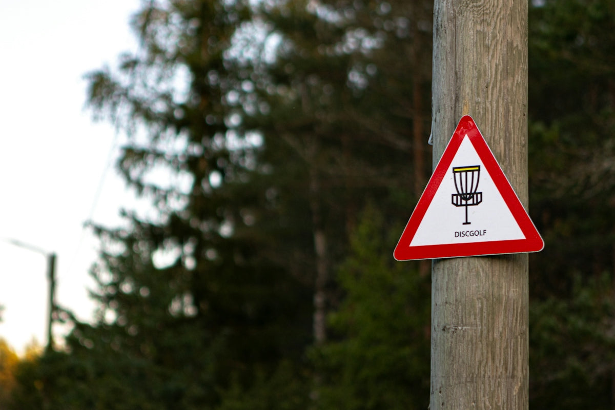a red and white sign on a wooden pole
